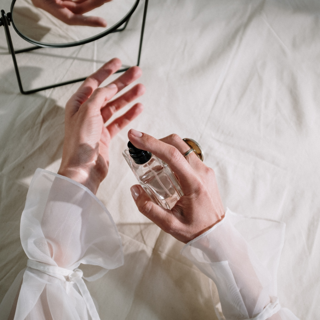 Photo of woman's arms putting on perfume 